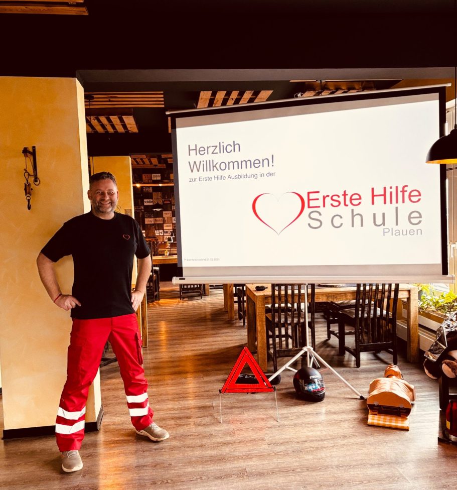 Erste Hilfe Kurs Plauen Fahrschule Führerschein Notfall Ersthelfer Vogtland Erste Hilfe Schule Plauen #rettenfetzt 1 Dozent vor Beamerleinwand mit dem Logo darauf.